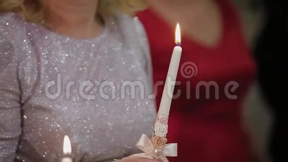 在婚礼上拿着燃烧的蜡烛的幸福女人视频的预览图