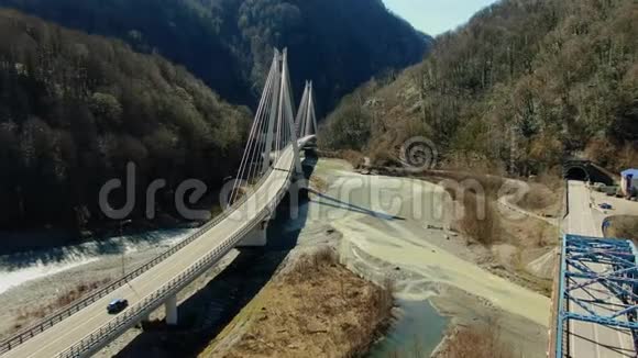 在晴朗的一天一座美丽的悬挂式汽车桥在一座山峡中穿过一条洞穴河流视频的预览图