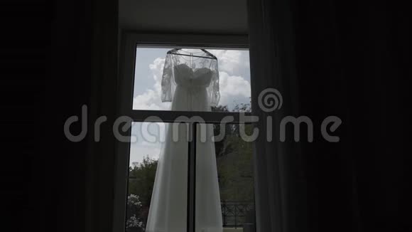 漂亮的现代婚纱挂在窗边的房子里视频的预览图