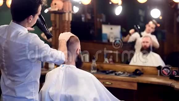 理发店理发师造型和吹风机的背面视图为留胡子的人理发复制空间视频的预览图