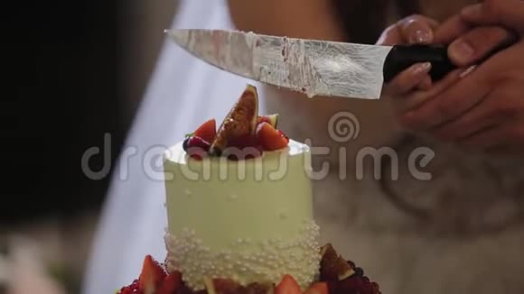 新婚快乐的新婚夫妇在庆祝时切了一个结婚蛋糕视频的预览图