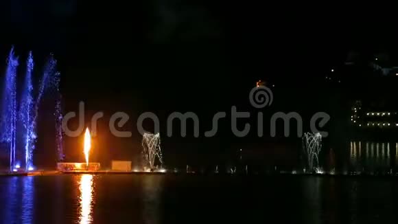 在水中倒影的夜空背景下喷泉呈现出五颜六色的明亮景象视频的预览图