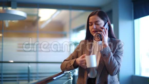 漂亮的女孩在她的智能手机上聊天喝咖啡视频的预览图