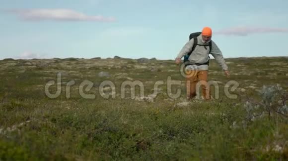 一个徒步旅行者跳过地面的空隙他在冻土带上行走视频的预览图