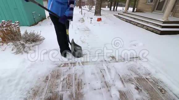 女人在寒冷中挣扎着铲雪她有困难慢动作视频的预览图