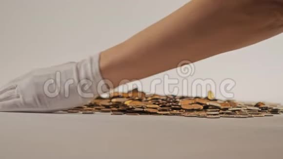 白手套的手舀起一堆金币他们整理和分散金钱在白色背景上加兰视频的预览图