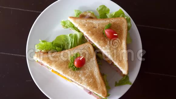 带烤面包火腿奶酪鸡蛋生菜培根的两种三明治的俯视图视频的预览图