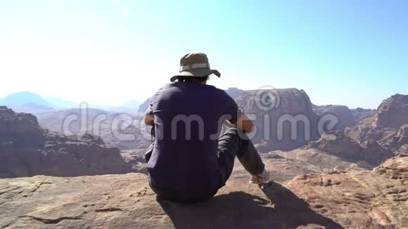 人坐在山顶看着美妙的景色约旦古城佩特拉的顶峰旅行者视频的预览图