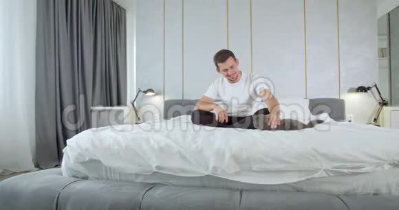 年轻人坐在床上抚摸他的猫现代公寓4K视频的预览图