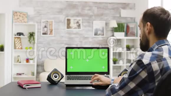 放大男人用绿色屏幕看手提电脑的镜头视频的预览图