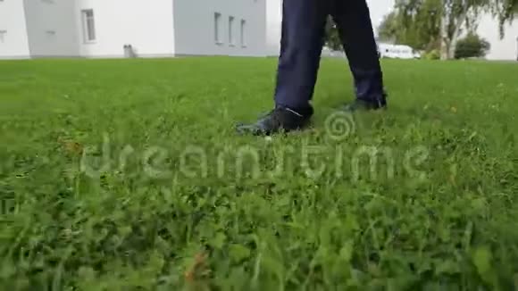 穿裤子的人在草地上行走的腿视频的预览图
