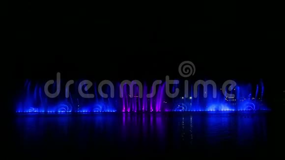 在水中反射的水上多种颜色的喷泉夜展视频的预览图
