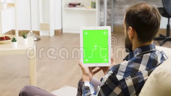 手持绿色屏幕数字平板电脑的人视频的预览图