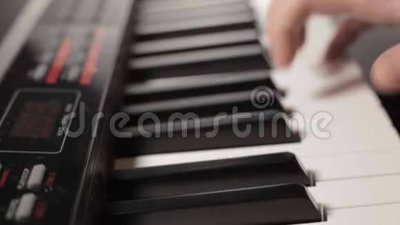 有白色袖子的男性手弹数字钢琴视频的预览图