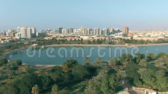 阿联酋阿尔巴沙池塘公园后面的海滨部分和迪拜市区的鸟瞰图视频的预览图