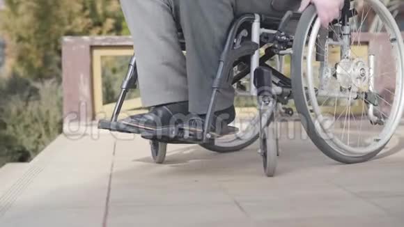 侧视特写的轮椅与无法辨认的老人滚动楼梯坡道可用概念残疾视频的预览图