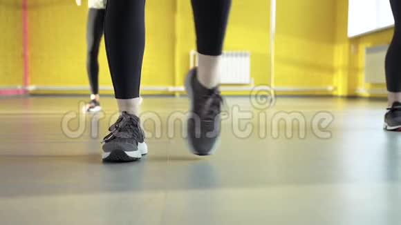 在工作室里做普拉提集体锻炼的女性腿部特写视频的预览图