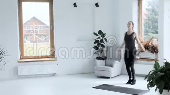 年轻健康的黑发美女在家锻炼女孩做跳跃和拍手视频的预览图