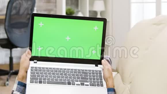 放大手持绿色屏幕笔记本电脑的人的视差镜头视频的预览图