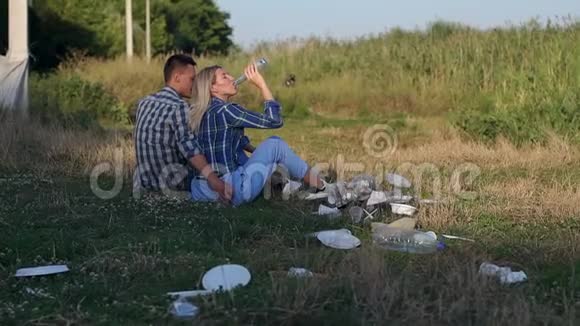 女孩把空瓶子扔到草地上环境污染视频的预览图