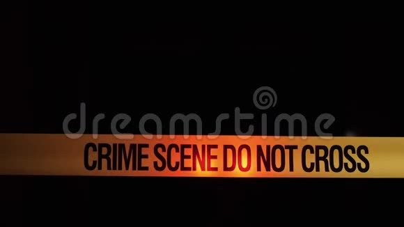 有犯罪现场铭文的障碍胶带在警车灯光的背景下视频的预览图