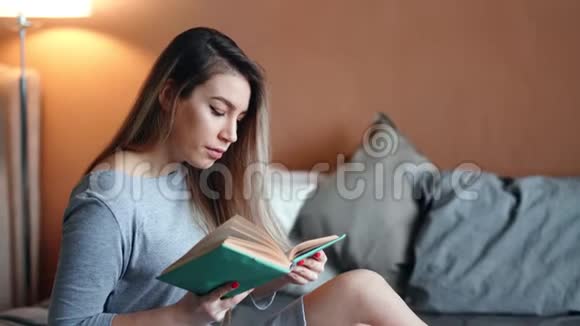 微笑的年轻女孩阅读有趣的小说文学有着积极的情感视频的预览图