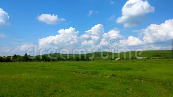 蓝天下绿草地的景观搭配白云延时运动自然与放松气候变化的概念视频的预览图