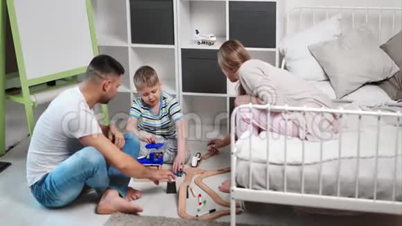 热情的家庭母子一起在舒适的卧室里玩玩具路视频的预览图