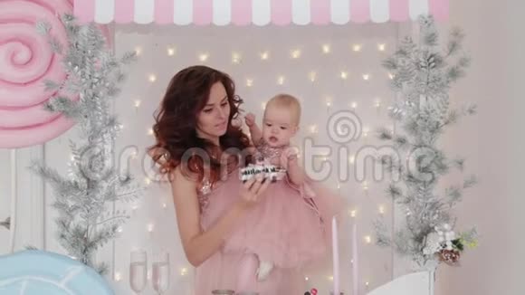 美丽的母亲和一个一岁的女儿穿着漂亮的裙子和新年装饰2020年新年视频的预览图