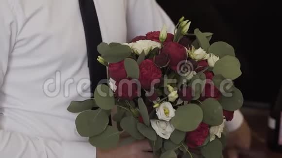 年轻的快乐男人手里拿着一束婚礼花束视频的预览图