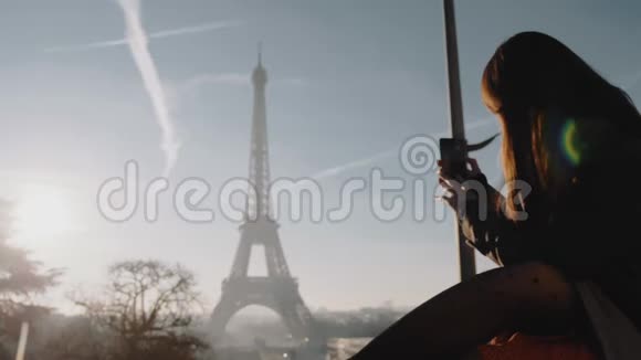 快乐年轻的旅游女游客为日落巴黎埃菲尔铁塔全景拍摄智能手机照片浪漫度假慢动作视频的预览图