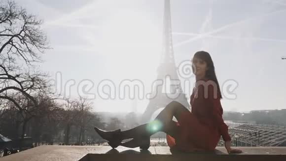 在巴黎埃菲尔铁塔的夕阳下美丽快乐的女人微笑着摆着红色的裙子视频的预览图