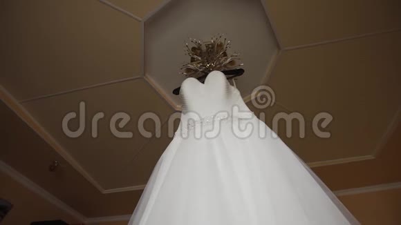 白色婚纱挂在房间里的吊灯上视频的预览图