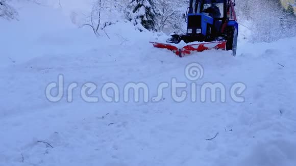 拖拉机普洛在森林的一条路上清除了雪雪清视频的预览图