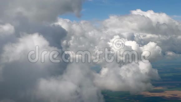 在一架飞机上飞过蓬松的雪白的云层从飞机的窗户可以看到壮观的景色飞机飞行视频的预览图