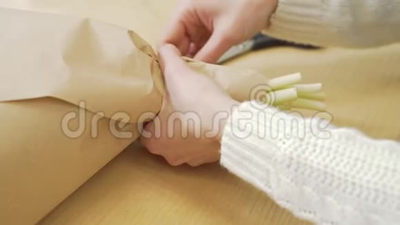用手工纸和丝带装饰花束的花匠的贴身女手视频的预览图