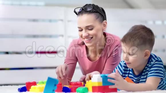 中等特写快乐可爱的妈妈喜欢和小可爱的儿子玩游戏玩具立方体视频的预览图