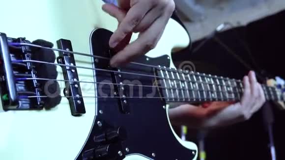 弹贝斯吉他在舞台灯光的光线下视频的预览图