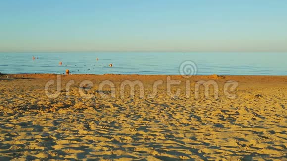 日出后平静的大海和金色的沙质海岸视频的预览图