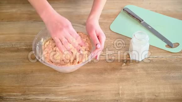 特写女性手搅碎肉女人的手在透明的碗里搅拌肉末视频的预览图