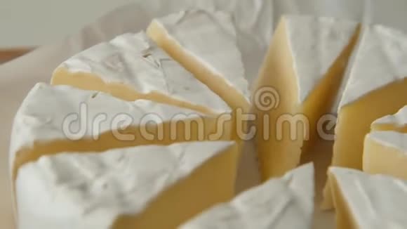 软奶酪布里或卡蒙伯特的切片旋转关闭视频的预览图