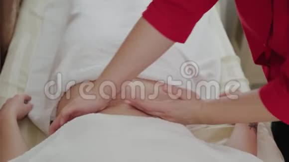 女性按摩治疗师对一个年轻女孩的胃进行按摩视频的预览图