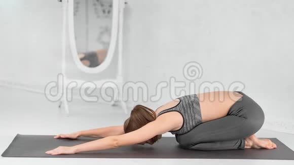 健康美丽的女性职业教练展示瑜伽姿势狗脸朝下放在垫子上视频的预览图