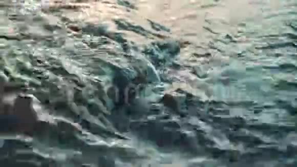 快速移动的水经过石头特写镜头绿松石颜色的小溪视频的预览图