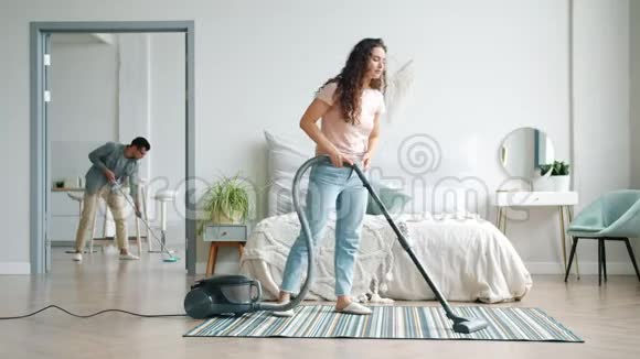 女孩和男人在家里用吸尘器和拖把打扫地板做家务视频的预览图