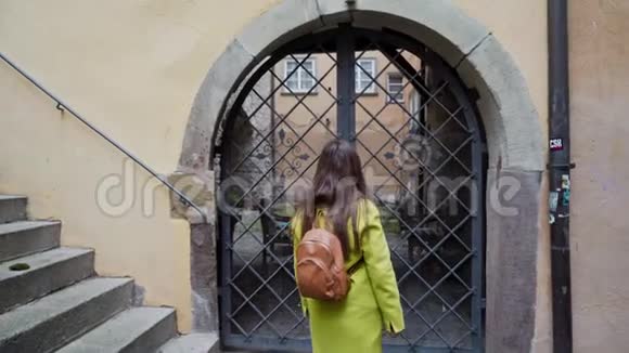 美丽的年轻长发女人穿着黄色外套背包去德国小城市散步快乐的女孩视频的预览图
