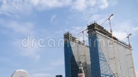 用起重机建造现代摩天大楼时光流逝蓝天上的云视频的预览图