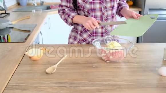 家庭主妇在碗中加入切碎的肉然后是鸡蛋洋葱和盐视频的预览图