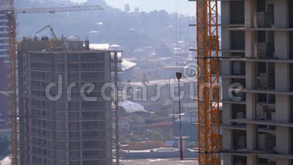 建筑工地上的塔式起重机在高层建筑上起重视频的预览图