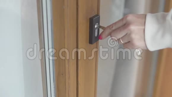 女人的手钥匙关上了房子的前门视频的预览图